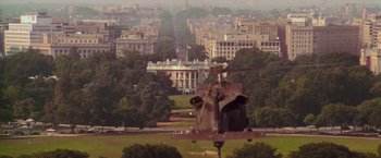 Movie still from “Air Force One” (1997), directed by Wolfgang Petersen – A helicopter flying over a large city with many buildings; Extreme Wide shot, Low angle
