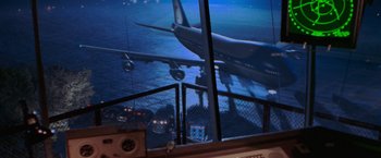 Movie still from “Air Force One” (1997), directed by Wolfgang Petersen – An airplane taking off at night from a runway; Extreme Wide shot, High angle