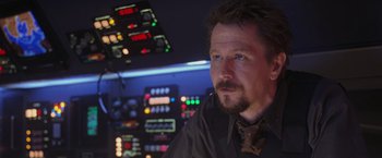 Movie still from “Air Force One” (1997), directed by Wolfgang Petersen – A person wearing a suit and tie; Close Up shot, Over the shoulder angle