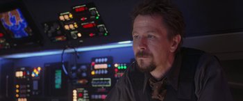 Movie still from “Air Force One” (1997), directed by Wolfgang Petersen – A person wearing a shirt and tie; Close Up shot, Over the shoulder angle