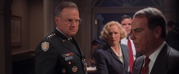 Movie still from “Air Force One” (1997), directed by Wolfgang Petersen – A man and a woman standing next to each other; Medium shot, Low angle