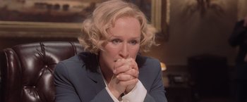 Movie still from “Air Force One” (1997), directed by Wolfgang Petersen – A person sitting with their hands clasped together; Close Up shot, Over the shoulder angle