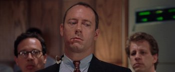 Movie still from “Air Force One” (1997), directed by Wolfgang Petersen – A person wearing a suit and tie; Close Up shot, Low angle