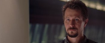 Movie still from “Air Force One” (1997), directed by Wolfgang Petersen – A person with a beard; Close Up shot, Over the shoulder angle