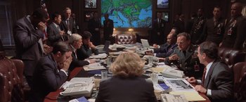 Movie still from “Air Force One” (1997), directed by Wolfgang Petersen – A group of people sitting around a table with laptops; Wide shot, High angle