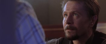 Movie still from “Air Force One” (1997), directed by Wolfgang Petersen – A person with a beard; Close Up shot, Over the shoulder angle