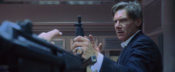 Movie still from “Air Force One” (1997), directed by Wolfgang Petersen – A man is holding a bottle in his hand; Close Up shot, Low angle