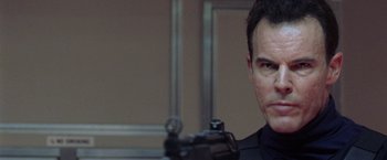 Movie still from “Air Force One” (1997), directed by Wolfgang Petersen – A person holding a gun; Close Up shot, Low angle