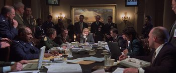 Movie still from “Air Force One” (1997), directed by Wolfgang Petersen – A group of people sitting around a table; Wide shot, High angle