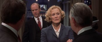 Movie still from “Air Force One” (1997), directed by Wolfgang Petersen – A man and a woman standing next to each other in a room; Medium shot, Over the shoulder angle