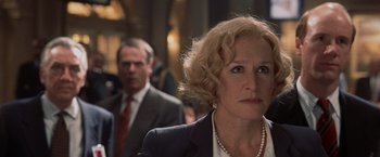 Movie still from “Air Force One” (1997), directed by Wolfgang Petersen – A person wearing a suit and tie; Close Up shot, Over the shoulder angle