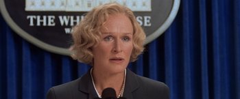 Movie still from “Air Force One” (1997), directed by Wolfgang Petersen – A person wearing a suit and tie; Close Up shot, Low angle