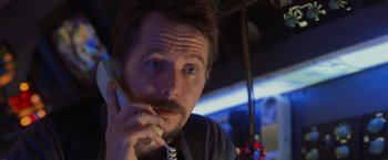 Movie still from “Air Force One” (1997), directed by Wolfgang Petersen – A person talking on a phone; Close Up shot, Low angle