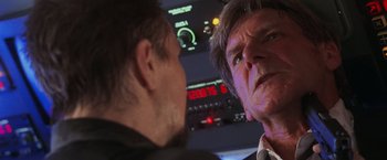 Movie still from “Air Force One” (1997), directed by Wolfgang Petersen – Two men are looking at each other in a plane; Close Up shot, Low angle