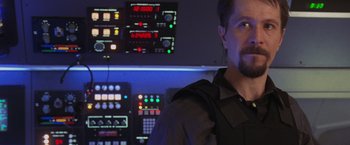 Movie still from “Air Force One” (1997), directed by Wolfgang Petersen – A man standing in front of a control panel; Close Up shot, Over the shoulder angle