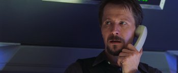 Movie still from “Air Force One” (1997), directed by Wolfgang Petersen – A person wearing a black shirt; Close Up shot, Low angle