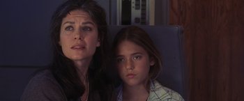 Movie still from “Air Force One” (1997), directed by Wolfgang Petersen – A woman and a young girl sitting next to each other; Close Up shot, Low angle