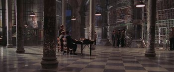 Movie still from “Air Force One” (1997), directed by Wolfgang Petersen – A group of people standing around a table; Extreme Wide shot, High angle