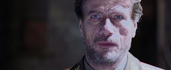 Movie still from “Air Force One” (1997), directed by Wolfgang Petersen – A person with a beard; Close Up shot, Over the shoulder angle