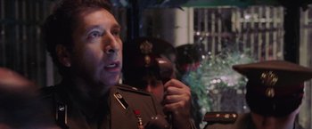 Movie still from “Air Force One” (1997), directed by Wolfgang Petersen – A person wearing a uniform holding a cell phone; Close Up shot, Over the shoulder angle