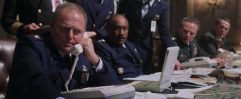Movie still from “Air Force One” (1997), directed by Wolfgang Petersen – A group of men in uniform sitting at a table; Medium shot, Low angle