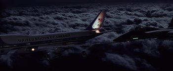 Movie still from “Air Force One” (1997), directed by Wolfgang Petersen – An american airlines plane flying through the night sky; Extreme Wide shot, Low angle