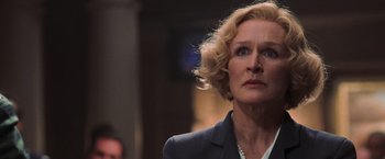 Movie still from “Air Force One” (1997), directed by Wolfgang Petersen – An older woman with blonde hair looking up; Close Up shot, Low angle