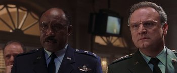Movie still from “Air Force One” (1997), directed by Wolfgang Petersen – A person wearing a military uniform; Close Up shot, Low angle