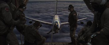 Movie still from “Air Force One” (1997), directed by Wolfgang Petersen – Two men standing next to an airplane in the sky; Wide shot, Low angle