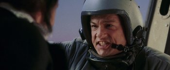 Movie still from “Air Force One” (1997), directed by Wolfgang Petersen – A man wearing a motorcycle helmet and a jacket; Close Up shot, Over the shoulder angle