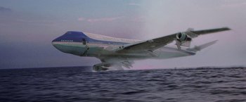 Movie still from “Air Force One” (1997), directed by Wolfgang Petersen – An air force one plane flying over a body of water; Extreme Wide shot, Low angle
