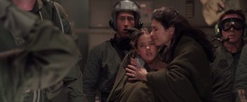 Movie still from “Air Force One” (1997), directed by Wolfgang Petersen – A man and a woman holding a young girl in her arms; Close Up shot, Over the shoulder angle