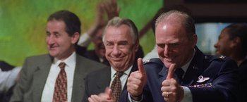 Movie still from “Air Force One” (1997), directed by Wolfgang Petersen – A group of men standing next to each other and giving thumbs up; Close Up shot, Low angle