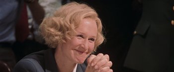 Movie still from “Air Force One” (1997), directed by Wolfgang Petersen – An older woman smiling and clapping her hands; Close Up shot, Low angle