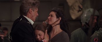 Movie still from “Air Force One” (1997), directed by Wolfgang Petersen – A man and a young woman are hugging each other; Close Up shot, Over the shoulder angle