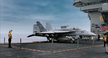 Movie still from “Aircraft Carrier: Guardian of the Seas” (2016), directed by Stephen Low – A fighter jet sitting on top of an aircraft carrier; Wide shot, High angle