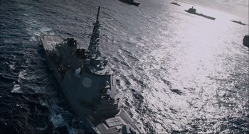 Movie still from “Aircraft Carrier: Guardian of the Seas” (2016), directed by Stephen Low – An aerial view of a boat in the water; Extreme Wide shot, High angle