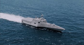 Movie still from “Aircraft Carrier: Guardian of the Seas” (2016), directed by Stephen Low – A large gray boat in the middle of the ocean; Extreme Wide shot, High angle