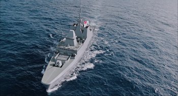 Movie still from “Aircraft Carrier: Guardian of the Seas” (2016), directed by Stephen Low – An aerial view of a boat in the ocean; Extreme Wide shot, High angle