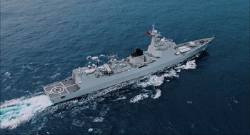 Movie still from “Aircraft Carrier: Guardian of the Seas” (2016), directed by Stephen Low – An aerial view of a military ship in the ocean; Extreme Wide shot, Overhead angle