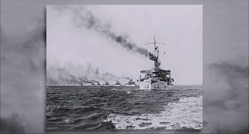 Movie still from “Aircraft Carrier: Guardian of the Seas” (2016), directed by Stephen Low – A black and white photo of a ship in the ocean; Extreme Wide shot, High angle