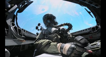 Movie still from “Aircraft Carrier: Guardian of the Seas” (2016), directed by Stephen Low – A man in a helmet sitting in the cockpit of an aircraft; Medium shot, Low angle