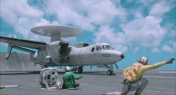 Movie still from “Aircraft Carrier: Guardian of the Seas” (2016), directed by Stephen Low – An airplane sitting on top of an airport runway; Extreme Wide shot, Low angle