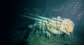 Movie still from “Aircraft Carrier: Guardian of the Seas” (2016), directed by Stephen Low – A ship is sitting on the bottom of the water; Extreme Wide shot, Overhead angle