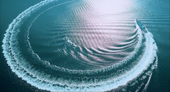 Movie still from “Aircraft Carrier: Guardian of the Seas” (2016), directed by Stephen Low – A large body of water that is very clear; Extreme Wide shot, Overhead angle