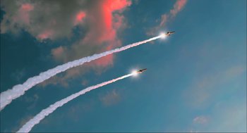 Movie still from “Aircraft Carrier: Guardian of the Seas” (2016), directed by Stephen Low – Two planes flying in the sky with smoke coming out of them; Extreme Wide shot, Low angle