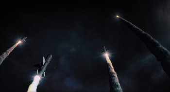Movie still from “Aircraft Carrier: Guardian of the Seas” (2016), directed by Stephen Low – A group of rockets flying in the sky at night; Extreme Wide shot, Low angle