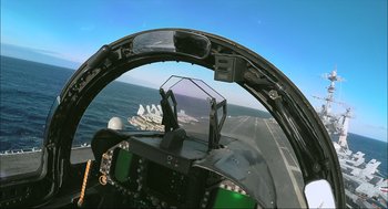 Movie still from “Aircraft Carrier: Guardian of the Seas” (2016), directed by Stephen Low – A view from inside an airplane looking out over the ocean; Extreme Wide shot, High angle
