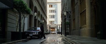Movie still from “The Game” (1997), directed by David Fincher – A man walking down a street with a car parked on the side of the street; Extreme Wide shot, High angle