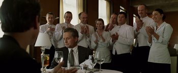 Movie still from “The Game” (1997), directed by David Fincher – A group of people standing in front of a table; Medium shot, Over the shoulder angle